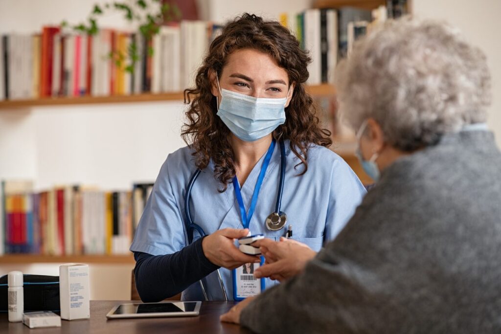 Doctor examining senior woman using oximeter at home