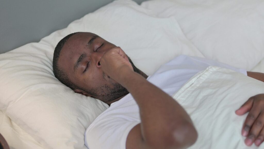 Young African Man with Cough Laying in Bed