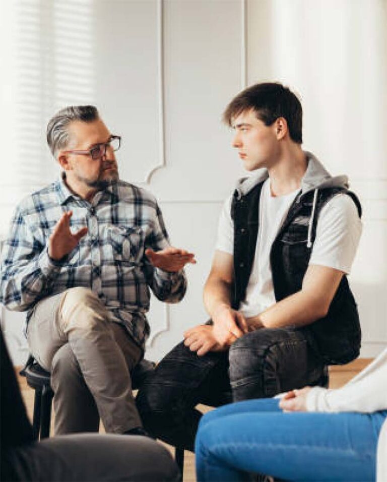 two men talking in group