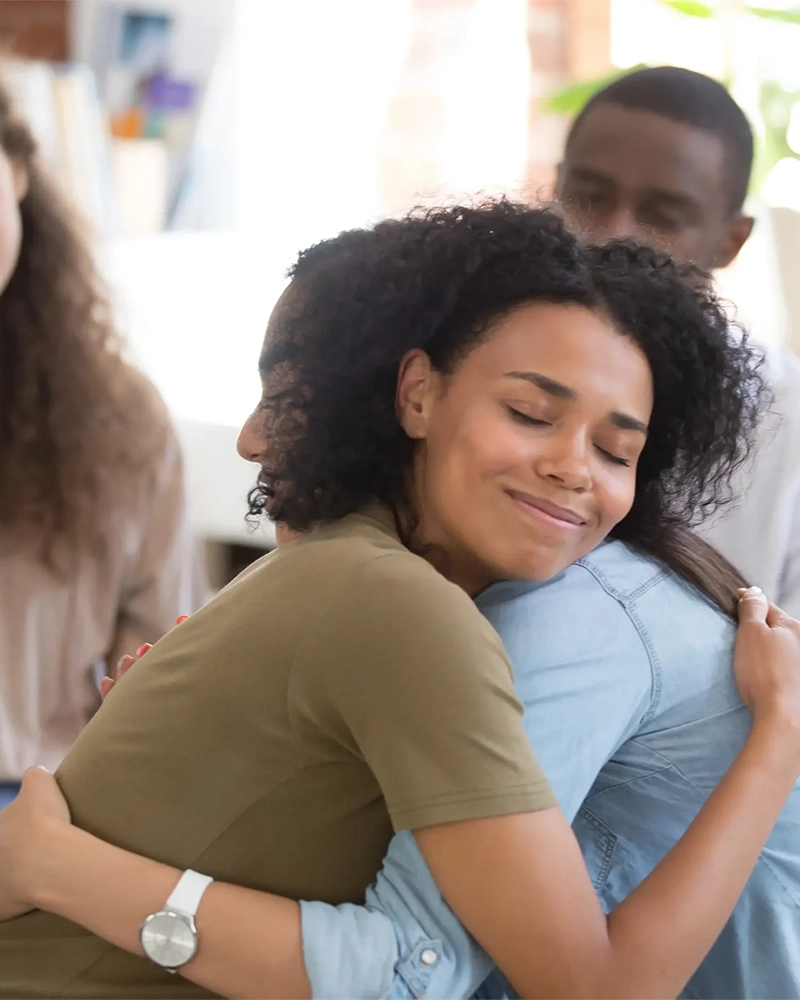 Two people hugging in group session