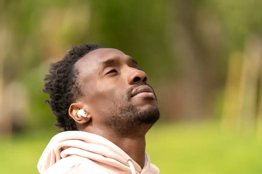 man looking up with earbuds in ears