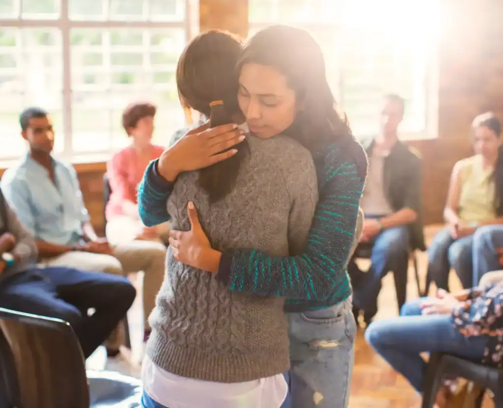 two friends hugging in a group