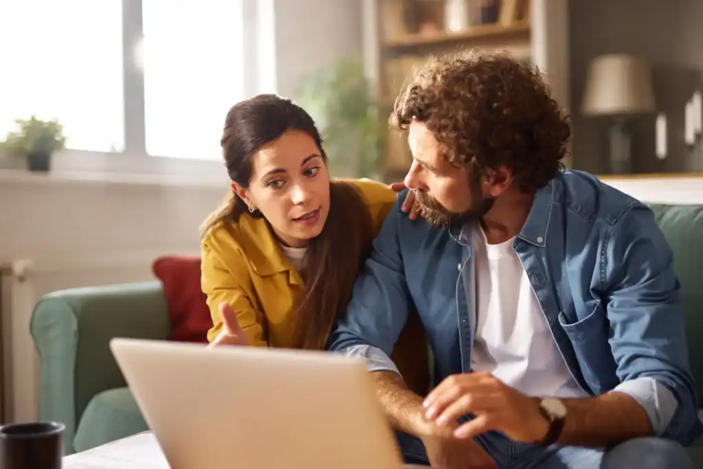 two people talking while on a laptop