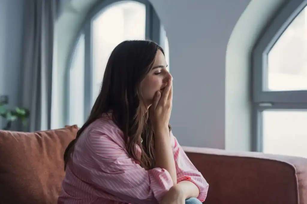 woman sitting with hand over her mouth