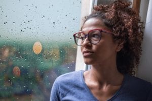 Woman staring out the window thinking about getting help for Oxycodone addiction.
