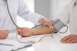 Doctor taking patients blood pressure. 